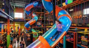 Urban Air Trampoline and Adventure Park: The Ultimate Family Fun Guide (2026) 4 Child descending a towering indoor slide at Urban Air