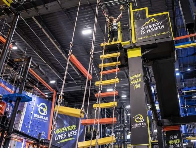 Urban Air Slides, Ninja Course & Ropes Course: Complete Attractions Guide 3 Climber reaching the top platform of the Stairway to Heaven attraction at Urban Air