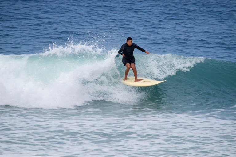 Hawaii Travel Guide 2026: Everything You Need Before Your Island Vacation 7 Surfer riding a wave on the North Shore of Oʻahu